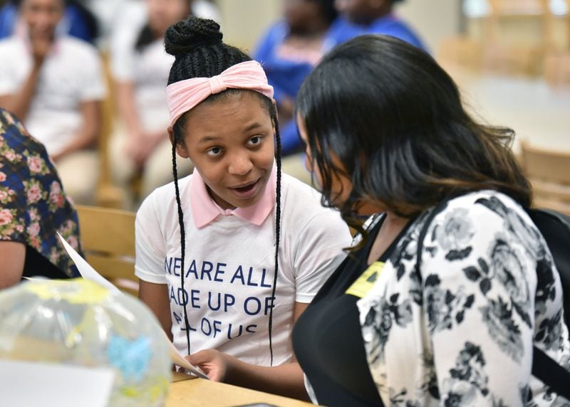 Amariah Caudle, 13, with her mother, Janell Caudle (right), reacts after she learned the result of her DNA test at Coretta Scott King Young Women’s Leadership Academy. Amariah thought she would have more European ancestry based on family stories. Her mother was surprised to see any traces of European ancestry after so many generations. HYOSUB SHIN / HSHIN@AJC.COM