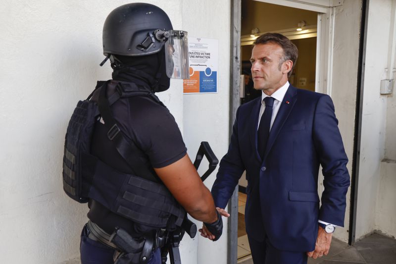 French President Emmanuel Macron shakes hands with a policeman upon his arrival at the central police station in Noumea, New Caledonia, Thursday, May 23, 2024. Macron has met with local officials in riot-hit New Caledonia, after crossing the globe in a high-profile show of support for the French Pacific archipelago gripped by deadly unrest.(Ludovic Marin/Pool Photo via AP)