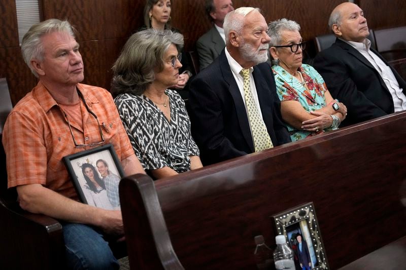 Family members of Dennis Tuttle and Rhogena Nicholas bring a photograph of the couple to the trial of retired Houston Police Department officer Gerald Goines Monday, Sept. 9, 2024 at Harris County Criminal Courthouse in Houston. Goines' trial on two felony murder charges in the January 2019 deaths of Tuttle and Nicholas began Monday. (Yi-Chin Lee/Houston Chronicle via AP)