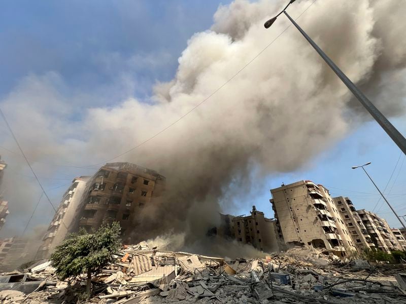 Smoke rises as a building collapses in Beirut's southern suburbs, Saturday, Sept. 28, 2024. (AP Photo/Hussein Malla)