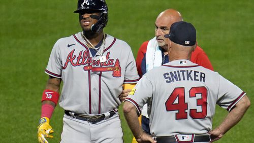 Atlanta Braves' Ronald Acuña Jr., left, grimaces as he leaves the game after being hit by a pitch from Pittsburgh Pirates' Colin Holderman during the sixth inning of a baseball game in Pittsburgh, Tuesday, Aug. 8, 2023. (AP Photo/Gene J. Puskar)