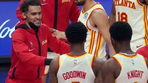 Atlanta Hawks guard Trae Young, left, celebrates a win with teammates Brandon Goodwin (0) and Nathan Knight (1) at the end of an NBA basketball game against the Orlando Magic Thursday, May 13, 2021 in Atlanta. (AP Photo/Tami Chappel)