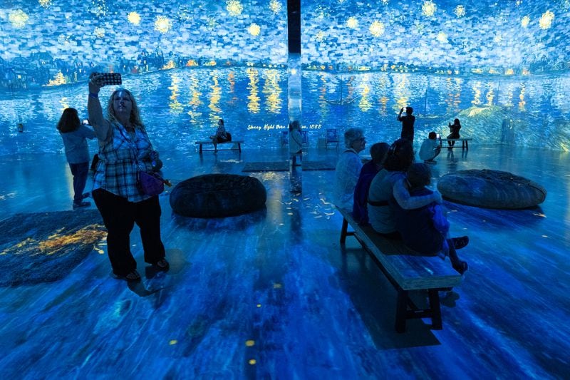 People take in the main room of Van Gogh: The Immersive Experience at Exhibition Hub Art Center Atlanta in Doraville on Monday, July 31, 2023.   (Ben Gray / Ben@BenGray.com)