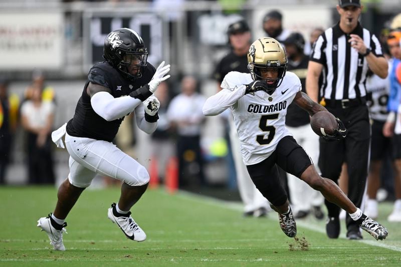 Colorado wide receiver Jimmy Horn Jr. (5) runs after catching a pass as Central Florida defensive end Jamaal Johnson, left, defends during the first half of an NCAA college football game, Saturday, Sept. 28, 2024, in Orlando, Fla. (AP Photo/Phelan M. Ebenhack)