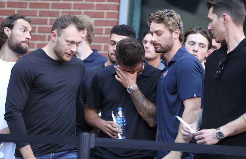 Columbus Blue Jackets player Cole Sillinger, center, reacts during the candlelight vigil to honor Blue Jackets hockey player Johnny Gaudreau, outside of Nationwide Arena in Columbus, Ohio, Thursday, Sept. 4, 2024. Gaudreau and his brother Matthew were killed by a motor vehicle last week while riding bicycles. (AP Photo/Joe Maiorana)