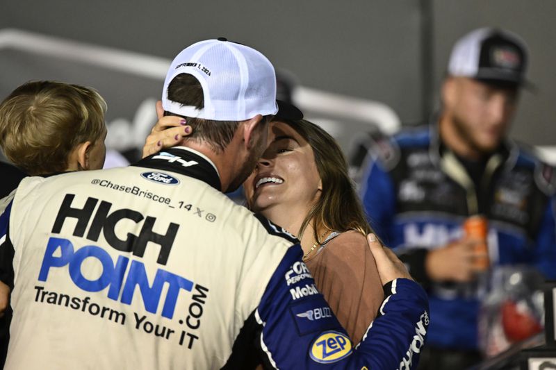 Chase Briscoe embraces his wife Marissa in Victory Lane after winning a NASCAR Cup Series auto race at Darlington Raceway, Sunday, Sept. 1, 2024, in Darlington, S.C. (AP Photo/Matt Kelley)