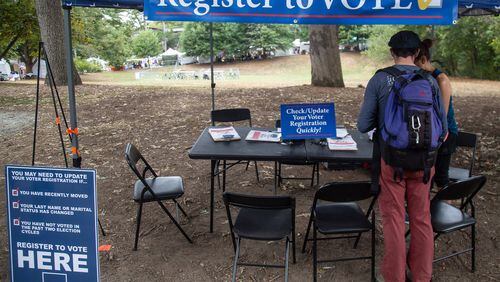 Greg Sawicki checks to make sure his voter registration is in order during the Candler Park Fall Fest 2019 in Atlanta. STEVE SCHAEFER / SPECIAL TO THE AJC