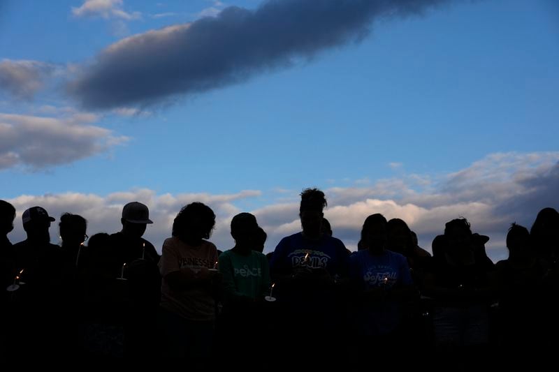 Mourners hold candles and stand silently during a vigil for victims of the Impact Plastics tragedy in the aftermath of Hurricane Helene in Erwin, Tenn., on Thursday, Oct. 3, 2024. (AP Photo/Jeff Roberson)