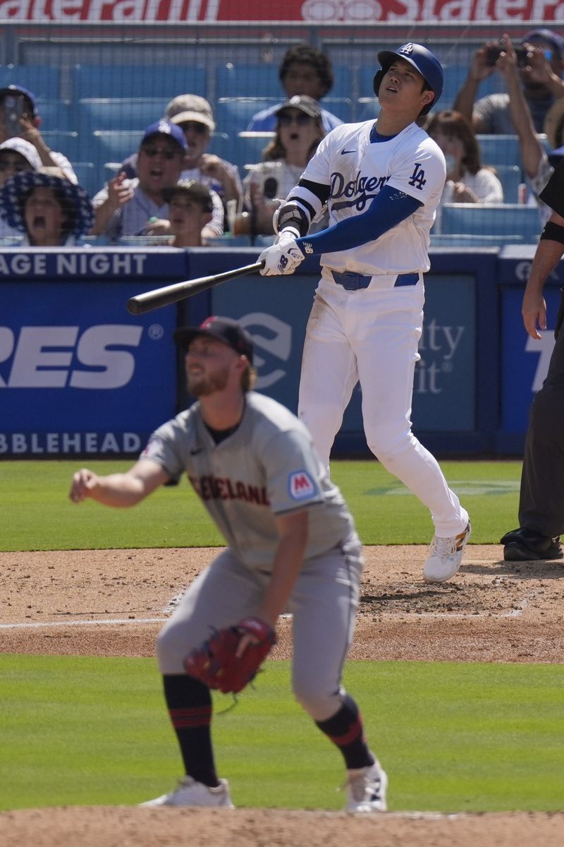 Los Angeles Dodgers' Shohei Ohtani, top, watches along with Cleveland Guardians starting pitcher Tanner Bibee as his ball goes out for a solo home run during the fifth inning of a baseball game, Sunday, Sept. 8, 2024, in Los Angeles. (AP Photo/Mark J. Terrill)