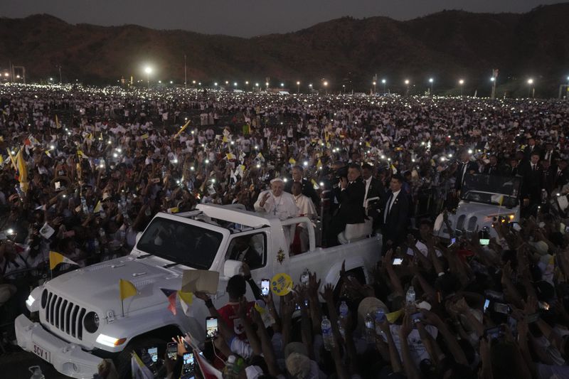 Pope Francis leaves after leading a holy mass at Tasitolu Park in Dili, East Timor, Tuesday, Sept. 10, 2024. With half of East Timor's population gathered at a seaside park, Francis couldn't help but oblige them with a final good night and languid loops in his popemobile, long after the sun had set and cellphone screens lighted the field. (AP Photo/Firdia Lisnawati)