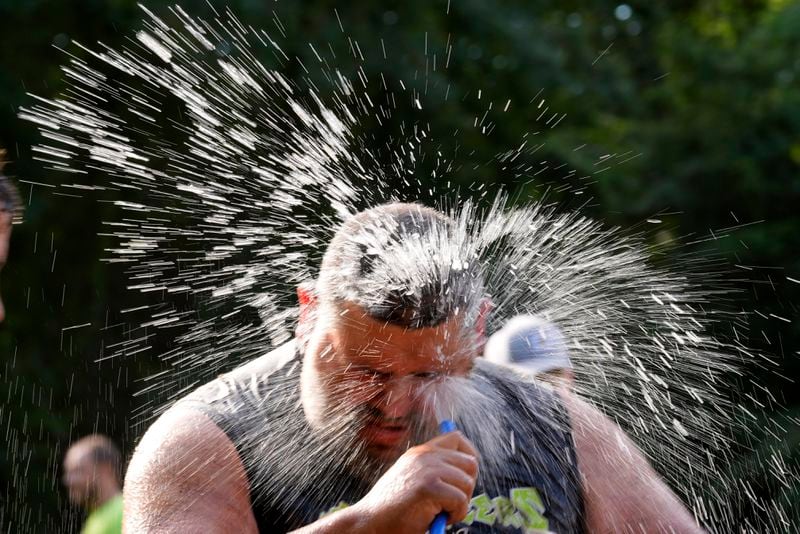 Jacob "Moose" Colon, of Westfield, Mass., of the Muckaneers, hoses off after a football game at the Mud Bowl in North Conway, N.H., Saturday, Sept. 7, 3024. (AP Photo/Robert F. Bukaty)