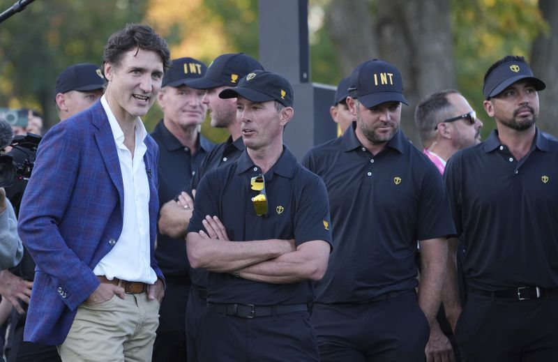 Canada Prime Minister Justin Trudeau chats with International team captain Mike Weir before the trophy presentation at the Presidents Cup golf tournament at Royal Montreal Golf Club Sunday, Sept. 29, 2024 in Montreal. (Christinne Muschi/The Canadian Press via AP)