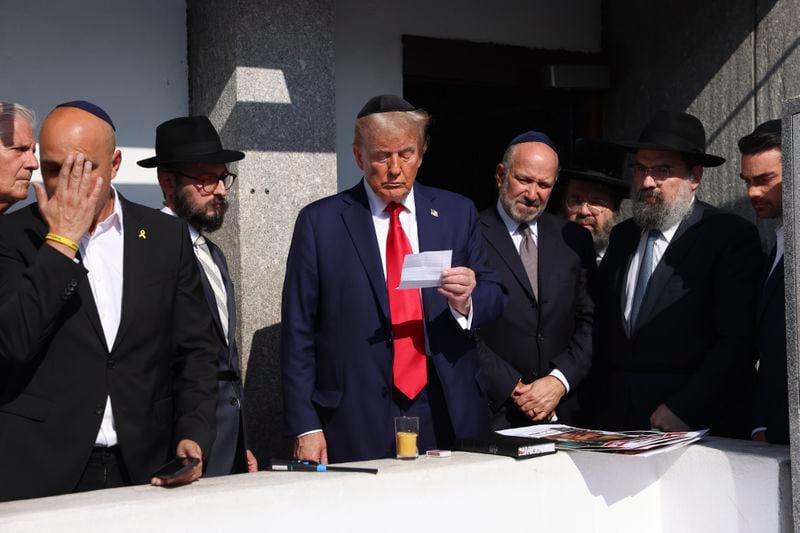 Republican presidential nominee former President Donald Trump, center, visits the gravesite of Rabbi Menachem Mendel Schneerson at Ohel Chabad-Lubavitch, Monday, Oct. 7, 2024, in New York. (AP Photo/Yuki Iwamura)