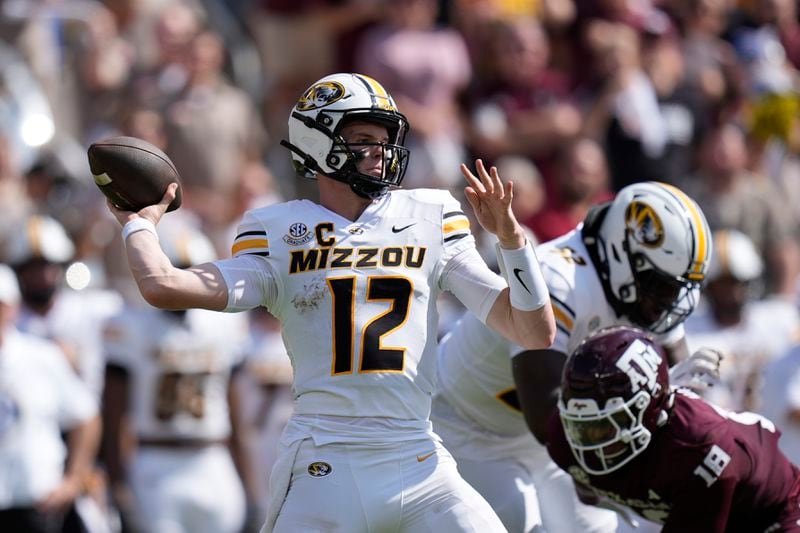 Missouri quarterback Brady Cook (12) is pressured by Texas A&M defensive lineman Cashius Howell (18) during the first half of an NCAA college football game Saturday, Oct. 5, 2024, in College Station, Texas. (AP Photo/Eric Gay)