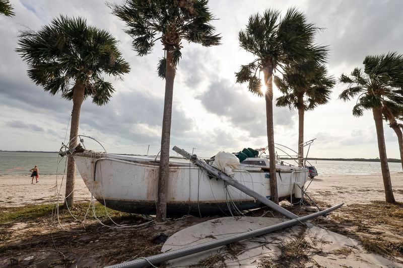 A boat pushed ashore on to the Dunedin Causeway by floodwaters from Hurricane Helene, Friday, Sept. 27, 2024, in Dunedin, Fla. (AP Photo/Mike Carlson)