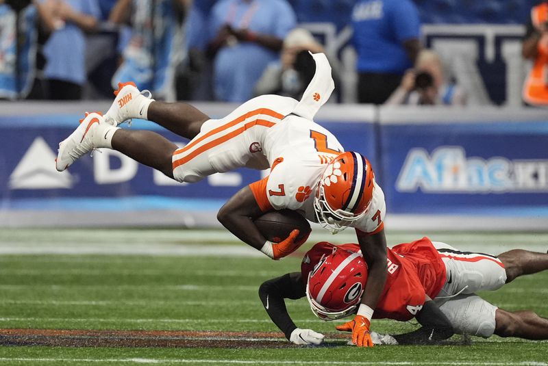 Clemson running back Phil Mafah (7) is brought down by Georgia defensive back KJ Bolden (4) after making a catch during the first half of an NCAA college football game Aug. 31, 2024, in Atlanta. (AP Photo/John Bazemore)