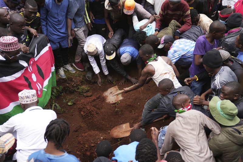 Relatives and friends bury the body of 19-year-old Ibrahim Kamau, at the Kariakor cemetery in Nairobi, Kenya Friday, June 28, 2024. Kamau was shot during a protest on Tuesday against the government proposed tax bill. Protesters stormed parliament on Tuesday and drew police fire in chaos that left several people dead. (AP Photo/Brian Inganga)