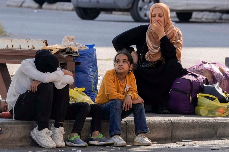 Families fleeing the Israeli airstrikes, react to the news of the death of Hezbollah leader Hassan Nasrallah in Beirut, Saturday, Sept. 28, 2024. (AP Photo/Bilal Hussein)