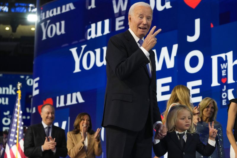 President Joe Biden and his grandson Beau Biden make the peace sign during the first day of Democratic National Convention, Monday, Aug. 19, 2024, in Chicago. (AP Photo/Jacquelyn Martin)