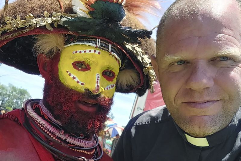 This undated photo provided by Fr Tomas Ravaioli shows a local villager posing for a photo with him in Goroka, Papua New Guinea. (Fr Tomas Ravaioli via AP)