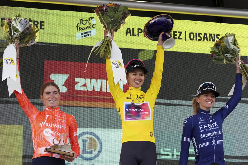 Tour de France Women winner Katarzyna Niewiadoma of Poland, wearing the overall leader's yellow jersey, Demi Vollering of The Netherlands, left and second place, and Pauliena Rooijakkers of The Netherlands, right and third place, celebrate on the podium after the eighth stage of the Tour de France Women cycling race with start in Le Grand-Bornand and finish in Alpe d'Huez, France, Sunday, Aug. 18, 2024. (AP Photo/Peter Dejong)