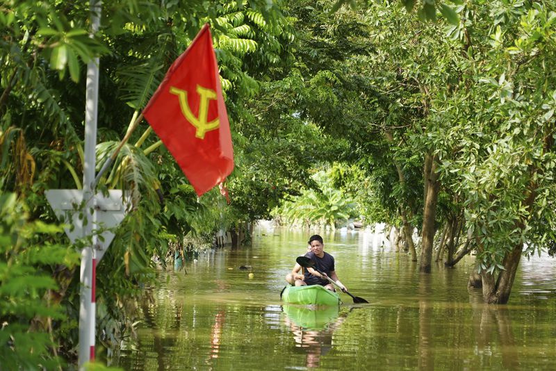 A man paddles a boat in the flood in the aftermath of Typhoon Yagi in An Lac village, Hanoi, Vietnam Friday, Sept. 13, 2024. (AP Photo/Hau Dinh)