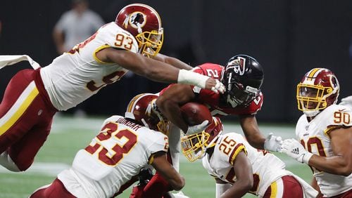 Falcons running back Ito Smith picks up short yardage against the Washington Redskins during the first quarter in a NFL preseason football game Thursday, Aug. 22, 2019, at Mercedes-Benz Stadium in Atlanta.