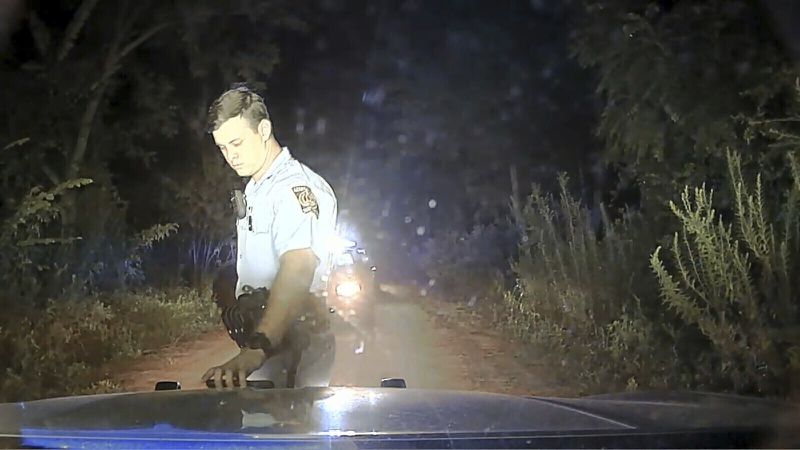 This image from a dashboard-mounted video camera on a Georgia State Patrol cruiser shows Trooper 1st Class Jake Thompson at the scene of an Aug. 7, 2020, shooting in which the trooper killed motorist Julian Lewis in Screven County, Ga. Thompson knocked Lewis' car into a ditch and shot him after trying to pull over the 60-year-old Black man for a broken taillight. Thompson was fired and charged with murder, but walked free after a grand jury declined to indict him. The newly released video raises new questions about the shooting. (Georgia Department of Public Safety/Ebony Reed, Louise Story via AP)