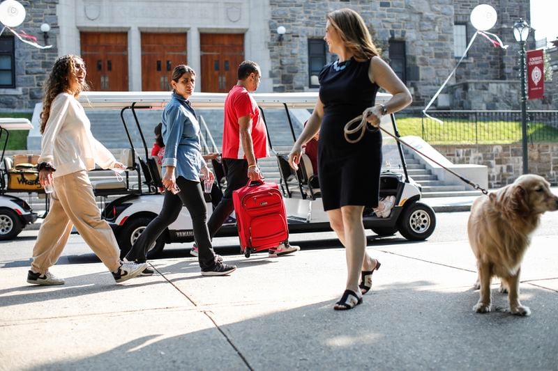 Tania Tetlow, president of Fordham University, holds her dog Archie as new students arrive during Move In Day at the Bronx campus, Sunday, Aug. 25, 2024, in New York. (AP Photo/Kena Betancur)