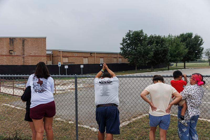 Family members of the Robb Elementary mass shooting victims Jackie Cazares and Tess Mata stand outside of the boarded up school building on Friday morning, May 24, 2024, in Uvalde, Texas. Friday marked two years since 19 fourth-graders and two teachers were killed by an 18-year-old gunman inside the school. (Sam Owens/The San Antonio Express-News via AP)