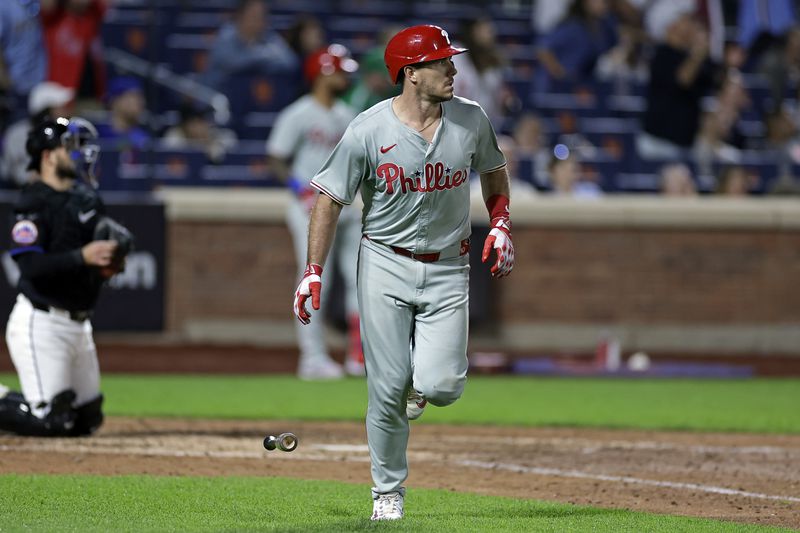 Philadelphia Phillies' J.T. Realmuto, right, watches his two-run home run during the eighth inning of a baseball game against the New York Mets, Friday, Sept. 20, 2024, in New York. (AP Photo/Adam Hunger)