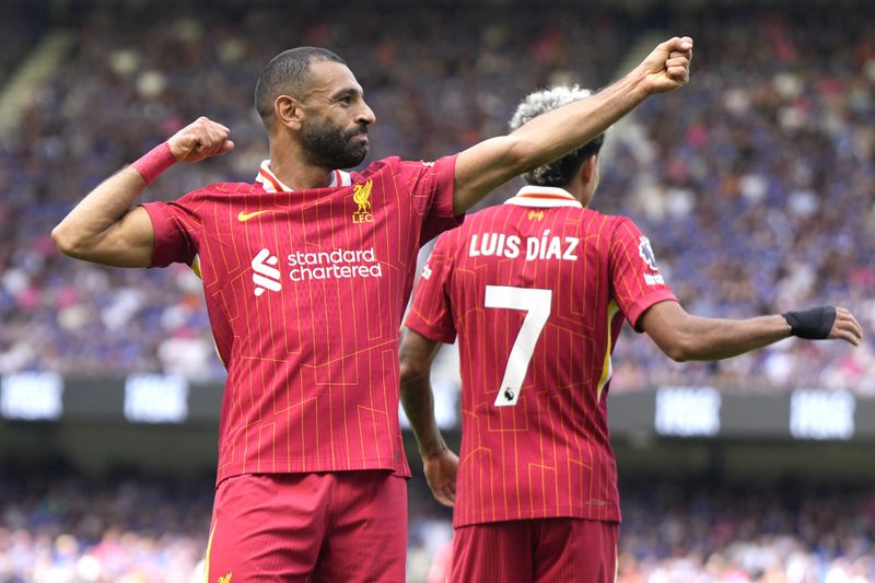 Liverpool's Mohamed Salah, left, celebrates after he scores his side's second goal during the English Premier League soccer match between Ipswich Town and Liverpool at Portman Road stadium in Ipswich, England, Saturday, Aug. 17, 2024. (AP Photo/Alastair Grant)