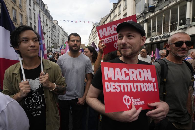 People, some carrying placards, participate in a protest demonstration responding to a call from the far-left party who criticized as a power grab the president's appointment of a conservative new prime minister, Michel Barnier, in Paris, France, Saturday, Sept. 7, 2024. (AP Photo/Michel Euler)