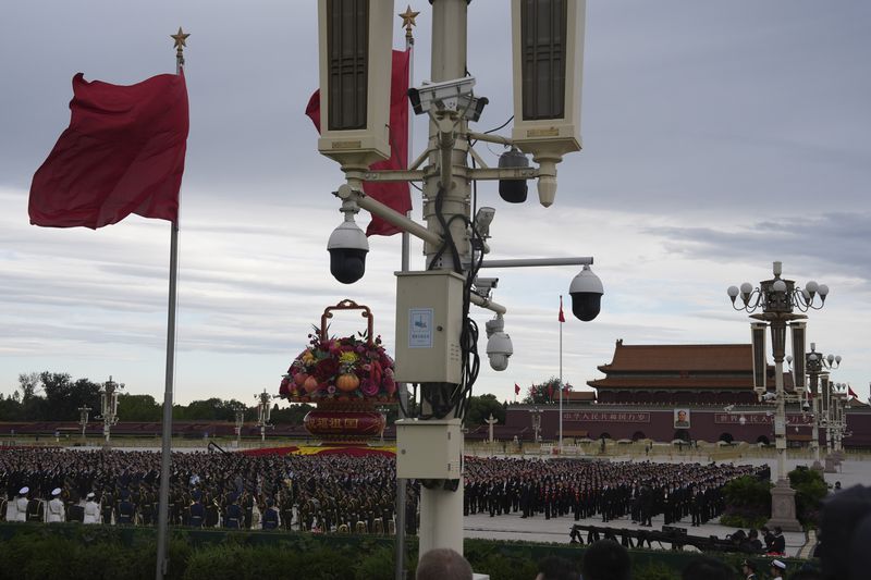 Security cameras overlook attendees gathered for a ceremony to mark Martyrs' Day ahead of the 75th anniversary of the founding of the People's Republic of China on Tiananmen Square in Beijing, Monday, Sept. 30, 2024. (AP Photo/Ng Han Guan)