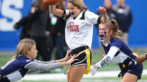 120921 Atlanta: Hillgrove quarterback Lacey Carder picks up a first down on a quarterback keeper between Marietta defenders in their GHSA Flag Football Championship Division 3 game on Thursday, Dec 9, 2021, in Atlanta.   “Curtis Compton / Curtis.Compton@ajc.com”`