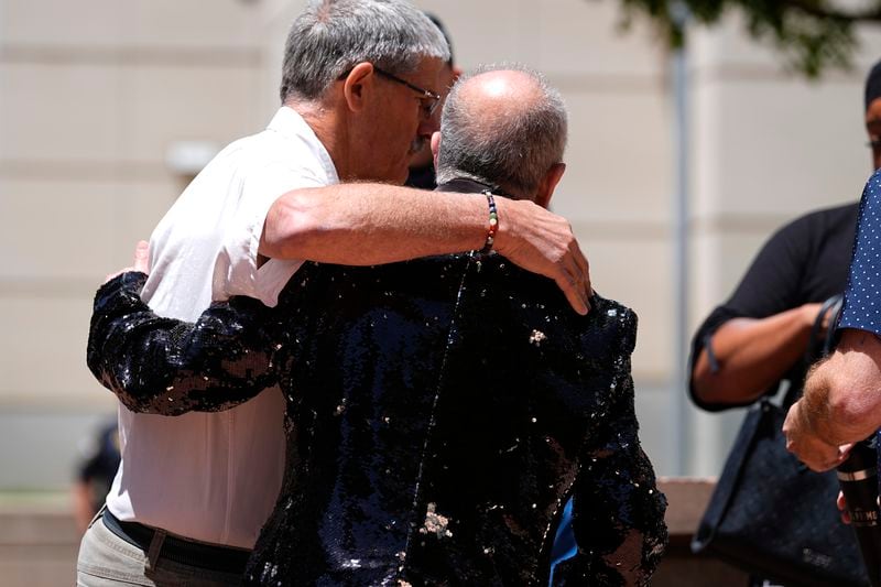 Ed Sanders, right, is hugged after speaking to reporters following the sentencing of Anderson Lee Aldrich, the shooter who killed five people and injured 19 others at an Colorado Springs, Colo., LGBTQ+ club, at a hearing in federal court Tuesday, June 18, 2024, in Denver. (AP Photo/David Zalubowski)