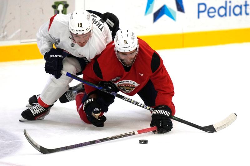 Florida Panthers left wing Matthew Tkachuk (19) and defenseman Aaron Ekblad (5) battle for the puck during NHL hockey training camp Thursday, Sept. 19, 2024, in Fort Lauderdale, Fla. (AP Photo/Lynne Sladky)