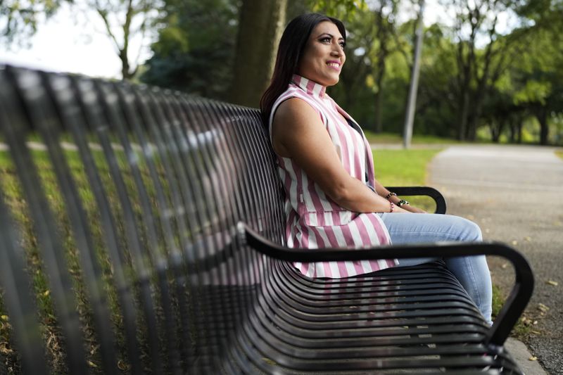 Julieth Luna Garcia, a transgender woman from El Salvador, sits on a bench as she looks at trees at Horner Park in Chicago, Monday, Sept. 30, 2024. (AP Photo/Nam Y. Huh)