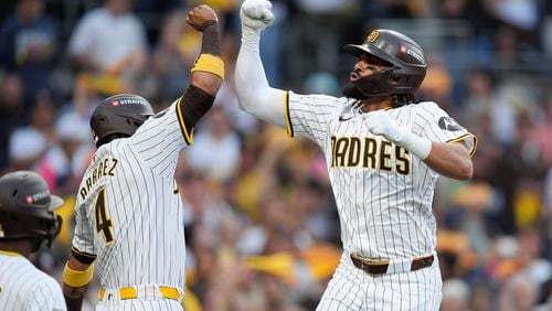 San Diego Padres' Fernando Tatis Jr., right, celebrates with Luis Arraez (4) after hitting a two-run home run during the first inning in Game 1 of an NL Wild Card Series baseball game against the Atlanta Braves, Tuesday, Oct. 1, 2024, in San Diego. (AP Photo/Gregory Bull)