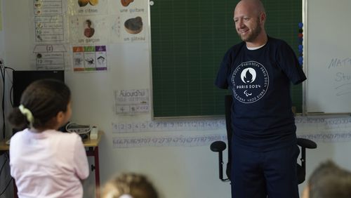 FILE - Archer Matt Stutzman of the United States talks to a pupil during a visit in a Paris school, in Paris, Oct. 4, 2023. Paralympians are not participating. They are competing. A number of athletes preparing for the Paris 2024 Paralympic Games proclaimed that message on their social feeds over the past few days, reminding the world that Olympians are not the only athletes coming to Paris looking for gold. (AP Photo/Thibault Camus, File)