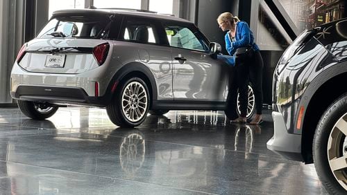 A prospective buyer examines a 2025 Cooper S hardtop on display on the showroom floor of a Mini dealership Monday, July 22, 2024, in Highlands Ranch, Colo. (AP Photo/David Zalubowski)