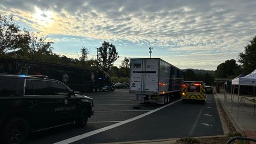 A tractor trailer is flanked by different law enforcement vehicles in its blind spots in the Marietta H.S. parking lot in the morning hours of September 30th, 2024.