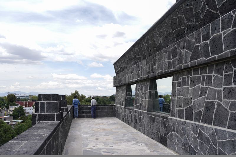 Visitors look out from the exterior of the Anahuacalli Museum in Mexico City, Tuesday, Aug. 20, 2024. Built by Mexican artist Diego Rivera, its name, Anahuacalli, translates from the Nahuatl language as "house surrounded by water." (AP Photo/Eduardo Verdugo)