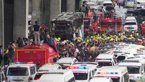 Rescuers gather at the site of a bus that caught fire, carrying young students with their teachers, in suburban Bangkok, Tuesday, Oct. 1, 2024. (AP Photo/Sakchai Lalit)