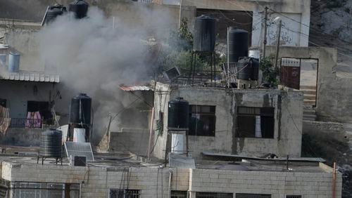 EDS NOTE: GRAPHIC CONTENT - An explosion is seen with three bodies lie motionless on rooftops in the West Bank town of Qatabiya during a raid, Thursday, Sept. 19, 2024. (AP Photo/Majdi Mohammed)