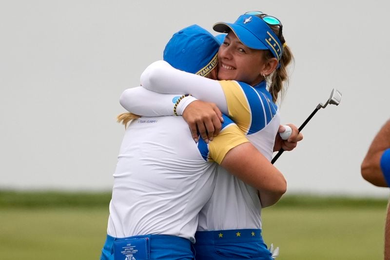 Europe's Emily Pedersen, right, hugs teammate Europe's Maja Stark after their victory on the 18th green during a Solheim Cup golf tournament foursomes match at Robert Trent Jones Golf Club, Friday, Sept. 13, 2024, in Gainesville, Va. (AP Photo/Matt York)