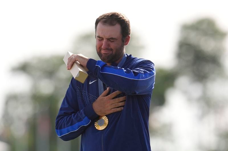 FILE - Gold medalist Scottie Scheffler, of the United States, cries as the national anthem of the US is played during the medal ceremony for men's golf at the 2024 Summer Olympics, Sunday, Aug. 4, 2024, at Le Golf National in Saint-Quentin-en-Yvelines, France. (AP Photo/George Walker IV, File)