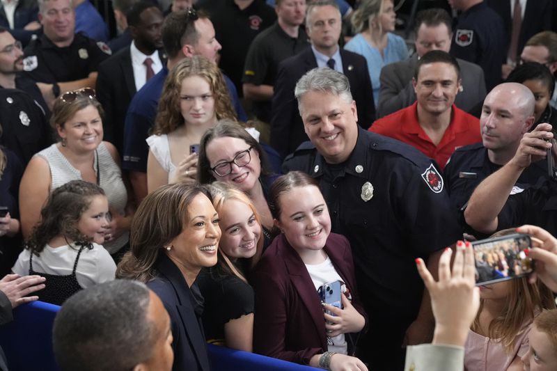 Democratic presidential nominee Vice President Kamala Harris, in foreground at left, takes a photo with attendees after speaking during an event at the Redford Township Fire Department North Station in Redford Township, Mich., Friday, Oct. 4, 2024. (AP Photo/Mark Schiefelbein)