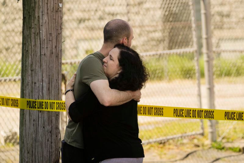 People embrace near the scene of a fatal shooting at Delaware County Linen in Chester, Pa., Wednesday, May 22, 2024. Authorities say a former employee armed with a handgun opened fire at a linen company in a Philadelphia suburb, killing multiple people and wounding three others. (AP Photo/Matt Rourke)