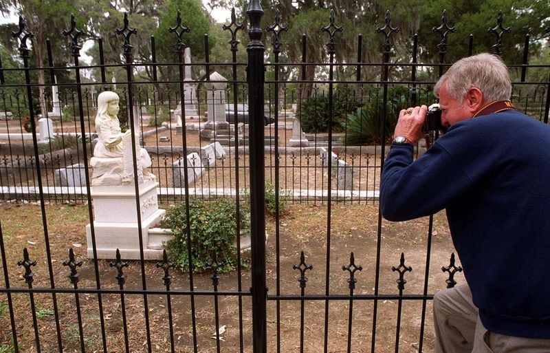 Al Waller, a tourist from Alabama, photographs the 111-year-old Gracie Watson grave at Bonaventure Cemetery in Savannah, Ga., on Tuesday, Jan. 18, 2000 through the rails of the iron fence erected in 1999 to protect the statue from vandalism. (AP Photo/Savannah Morning News, Steve Bisson)